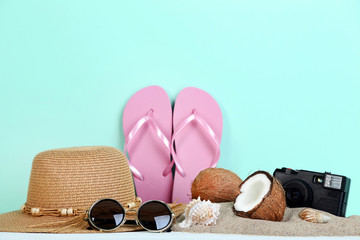 Summer accessories with seashells and coconuts on mint background