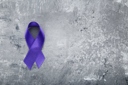 Purple ribbon on grey background. Cancer concept