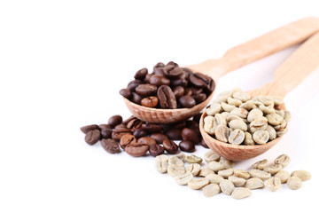 Green and brown coffee beans in spoons isolated on white background