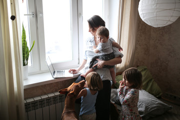 Mom with children and dog looking for laptop