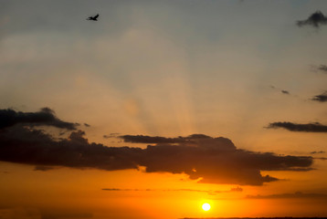 Fototapeta na wymiar Golden sun rays shooting upwards through a cloud.
