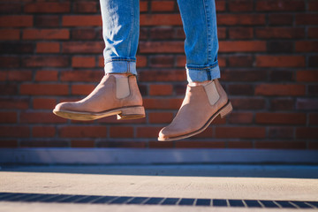 Leather shoes in air. Woman wearing jeans and leather boots