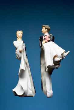 Bride and groom broken figurines against blue background