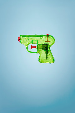 Green water gun on blue background