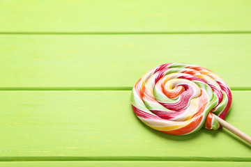 Colorful lollipop on green wooden table