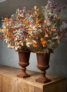 Flower pots on wooden table against gray wall