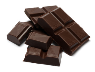Dark organic chocolate pieces isolated on white background