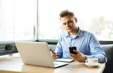 Stylish young man calling by the phone to solve business problems. Online consultation by phone. Freelancer discussing the development and planning of his online project. Outsourcing. Mobile services.