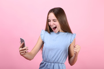 Naklejka premium Screaming girl with smartphone on pink background