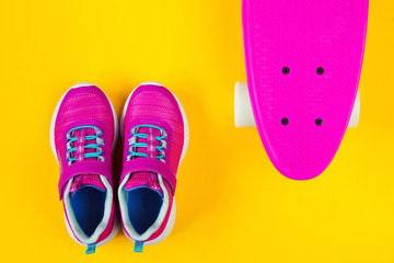 pink sneakers and skateboard flat lay