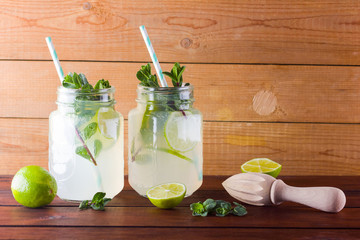 Mojito and mint on wooden background. Refreshing cocktail with lime and fresh mint on wooden...