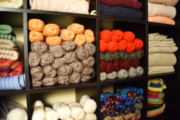 Workplace knitter. Shelves with yarn and knitted products.