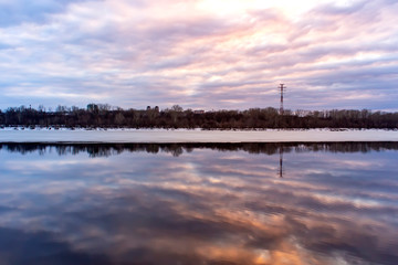 Beautiful reflection of the sky at sunset in the water on the river. Spring background.