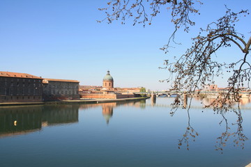 Fototapeta na wymiar The Saint Pierre bridge passes over the Garonne river and Hospital de La Grave in Toulouse, Haute Garonne, Occitanie, France