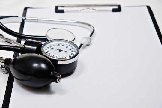phonendoscope and tonometer  with a folder with white sheets of paper   on a white background