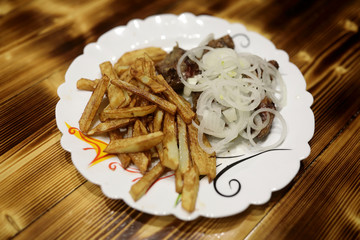 Slices of kebab with potatoes and onions