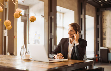 Young handsome businessman conducting negotiations with investors. Electronic business. Alternative...