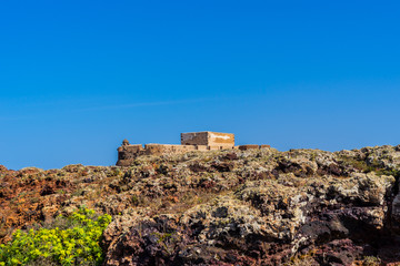 Fototapeta na wymiar Spain, Lanzarote, Ancient castle santa barbara behind colorful volcanic rock