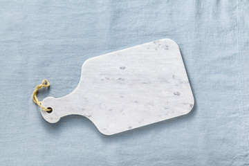 marble cutting board on a blue linen tablecloth. empty form for recipes, restaurants menu