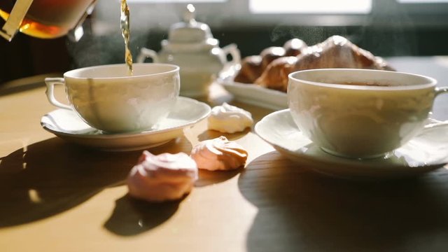 ideal morning moment. tea is poured into cups from french press. Croissants and sweets. Sweet breakfast breakfast. Video footage