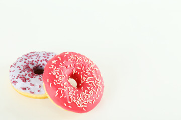 Vibrant composition of lush donut with colorful sprinkled icing, on bright background with a lot of copy space for text. Tasty but unhealthy food concept. Close up, flat lay, top view.