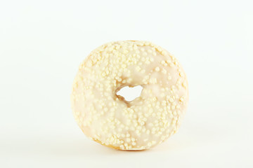 Vibrant composition of lush donut with colorful sprinkled icing, on bright background with a lot of copy space for text. Tasty but unhealthy food concept. Close up, flat lay, top view.