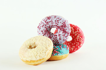 Vibrant composition of lush donut with colorful sprinkled icing, on bright background with a lot of copy space for text. Tasty but unhealthy food concept. Close up, flat lay, top view.