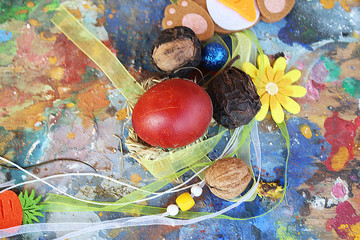 Red easter egg on colorful wooden artistic palette