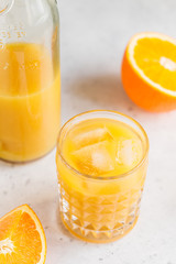 Fresh orange juice with ice cubes in a glass on a table. The concept of healthy eating.