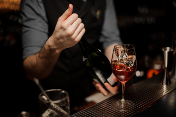 Bartender prepares cocktail on a bar counter
