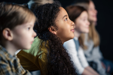 selective focus of african american girl watching movie in cinema with friends
