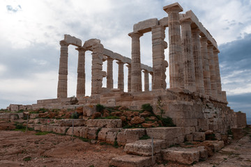 Fototapeta na wymiar Greek temple ancient stones orange clouds blue sky