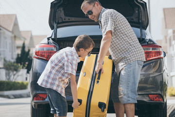 Happy father and son getting ready for road trip on a sunny day.