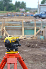 Surveyor's work tool against the background of the construction site. Measuring tool of the geodetic service.