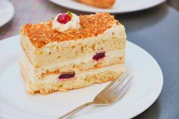 slice of Frankfurt crown cake (Frankfurter Kranz) on a white plate on a sunny day outdoor