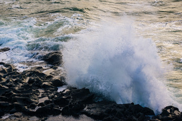 Fototapeta na wymiar Waves crash on rocks off the coast of County Clare Ireland.