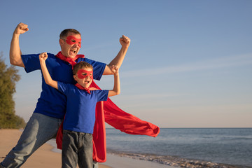 Father and son playing superhero on the beach at the day time.