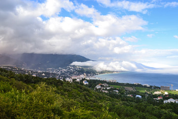 Beautiful nature phenomenon. Thick descent clouds descend from the mountains directly into the...