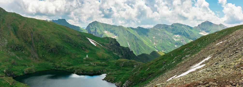 panorama of a fagaras mountains in summer. lake between the hills. beautiful scenery of romania. wonderful destination for a weekend vacation