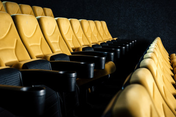 selective focus of comfortable orange cinema seats with cup holders