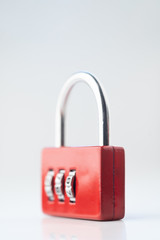 Close up photo of red closed code padlock isolated on white or gray background