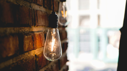Decorative antique edison style light tungsten bulbs against brick wall background