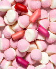 Creative food concept photo of cosmetics beauty products lipstick with candies sweets on white background.