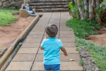 A tender little boy walks alone on a path