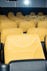 rows of comfortable, numbered orange seats in cinema hall