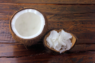 fresh coconut flakes and chips placed in bark isolated on rustic wooden background