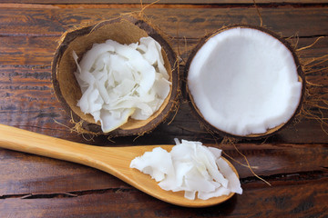 fresh coconut flakes and chips placed in bark isolated on rustic wooden background