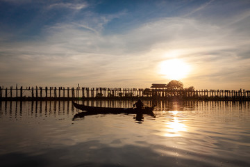 Fototapeta na wymiar Sunset over U Bein Wooden bridge with locals' and tourists' silhouettes, Mandalay, Myanmar (Burma).