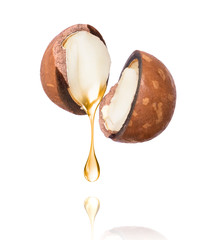 Oil of macadamia nut is dripping on a white background.