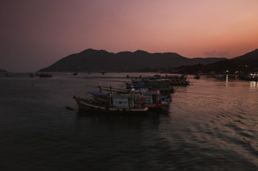 Fototapeta premium tranquil scene of fishing boats during sunrise in a bay in Koh Tao, Thailand